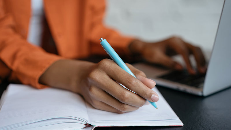 woman taking notes on her personal finances